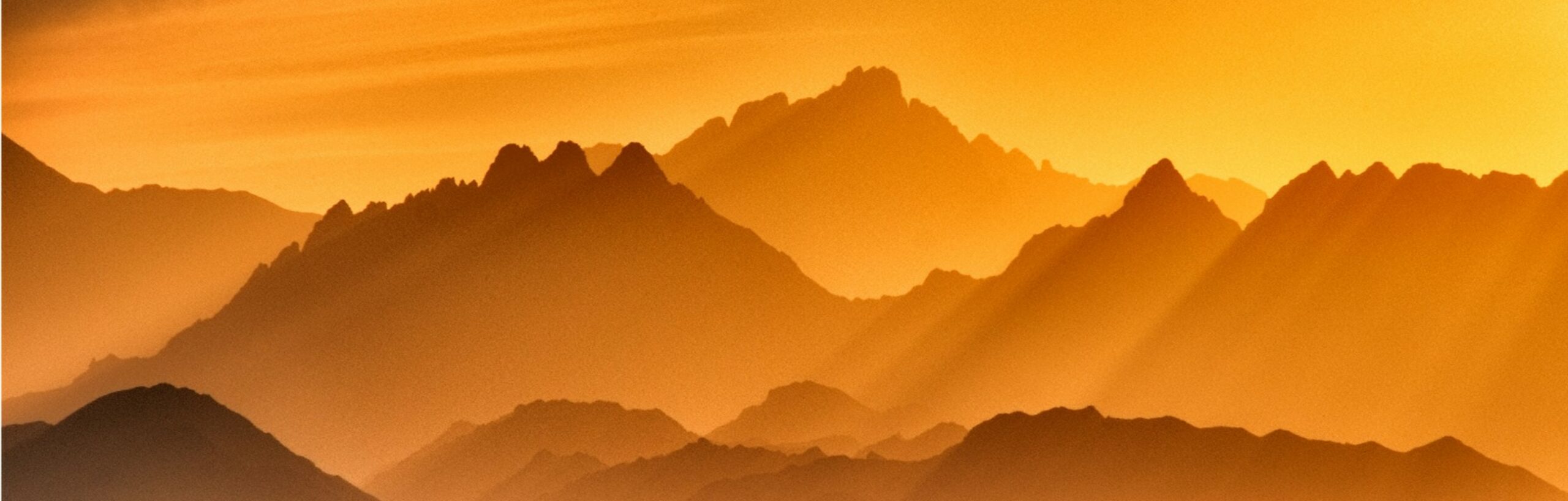 golden sun-soaked jagged mountains, rays of golden light hit them from the rhs