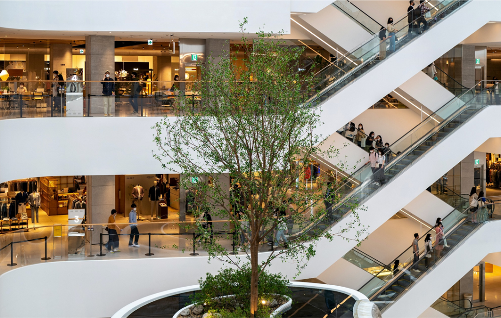 A white multi-level shoppping centre, with a tree in the centre - In-building coverage testing without an engineer on-site